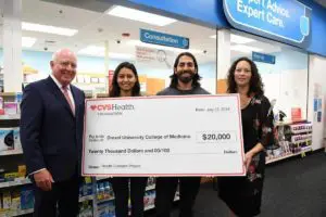 CVS-Health four people smiling holding cvs foundation check