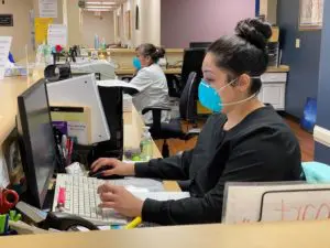 Matthew 25 Health and Dental Clinic employees on computer