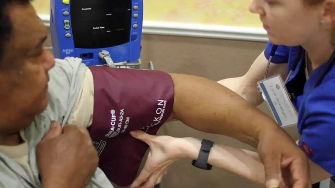 person checking someone's blood pressure