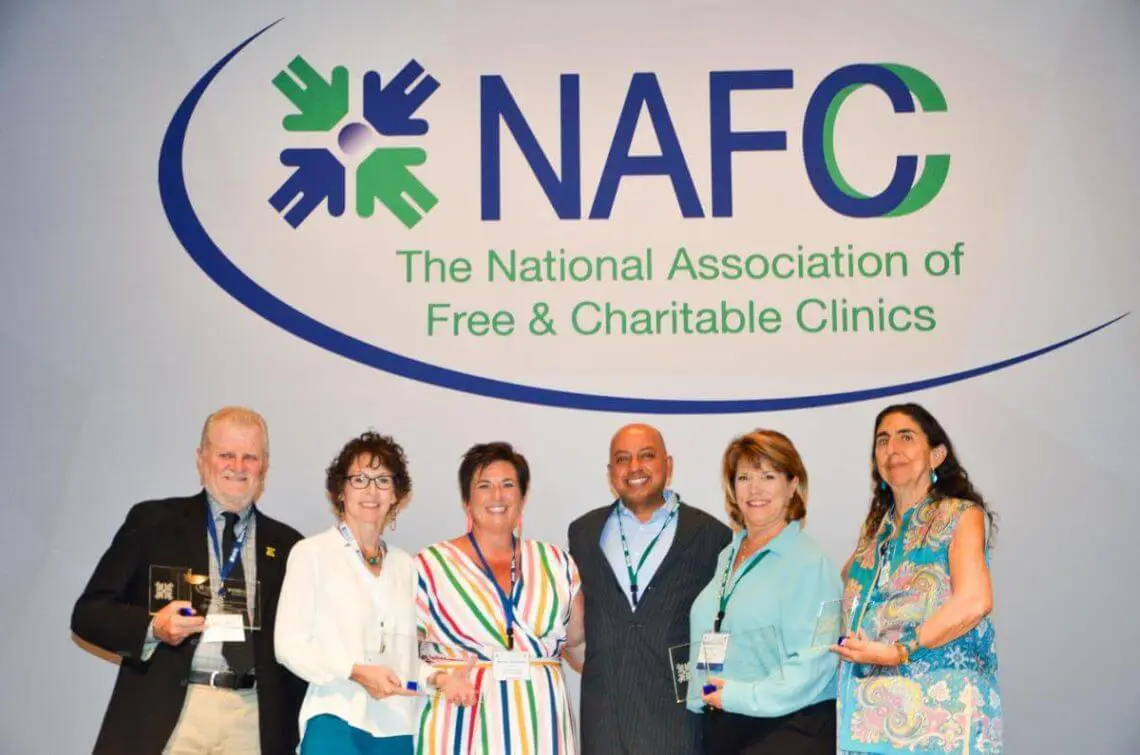 group of people smiling with awards