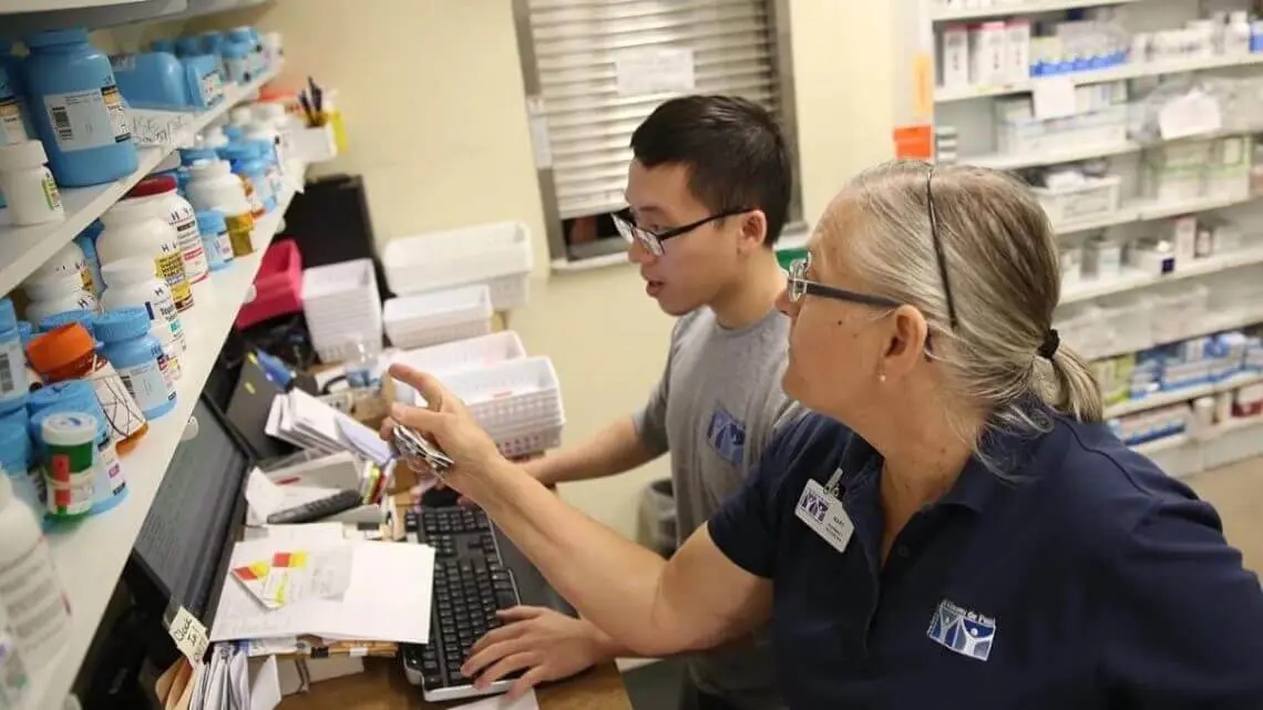 Workers looking at something on a computer in pharmacy