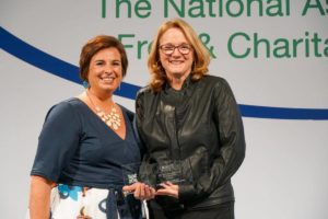 two ladies smiling with award