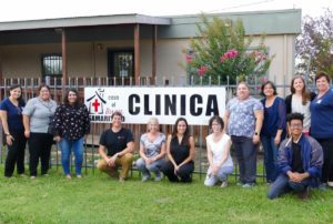 group of people smiling in front of CLINCA sign